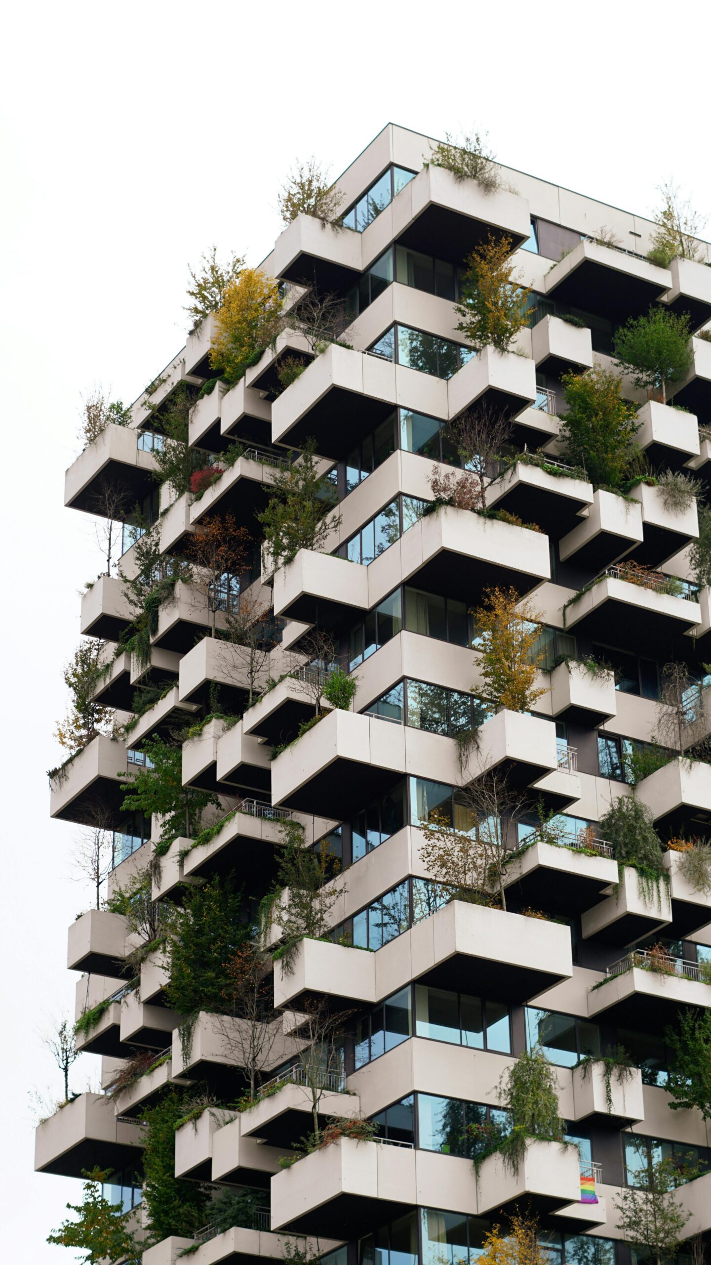 Unique architectural skyscraper featuring geometric balconies and lush greenery.
